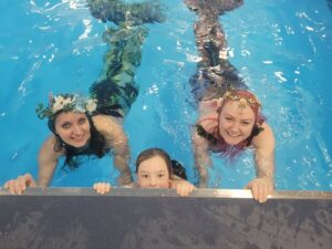 a cheeky mermaid peeking from the swimming pool